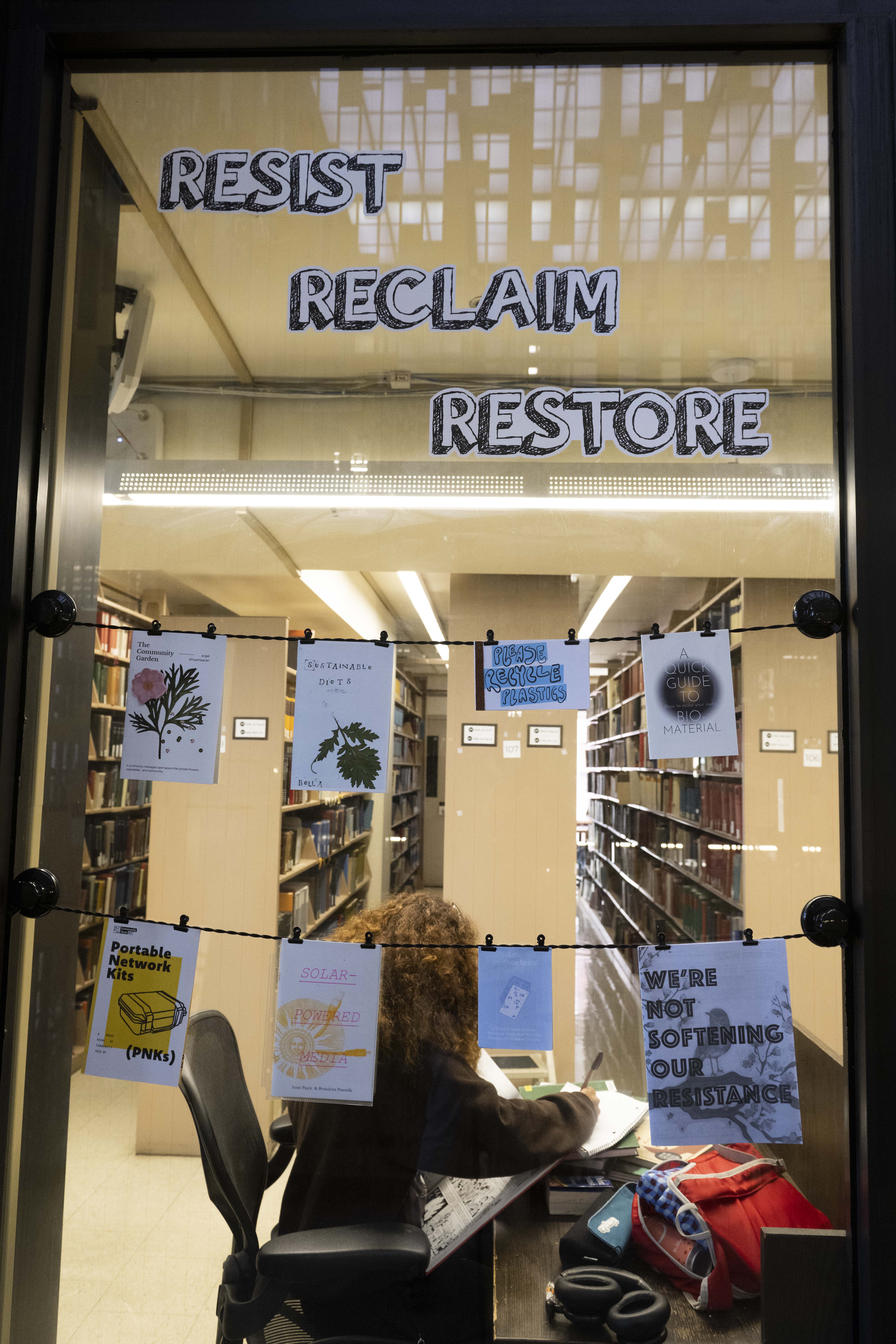 Detail image of zines hung against glass window