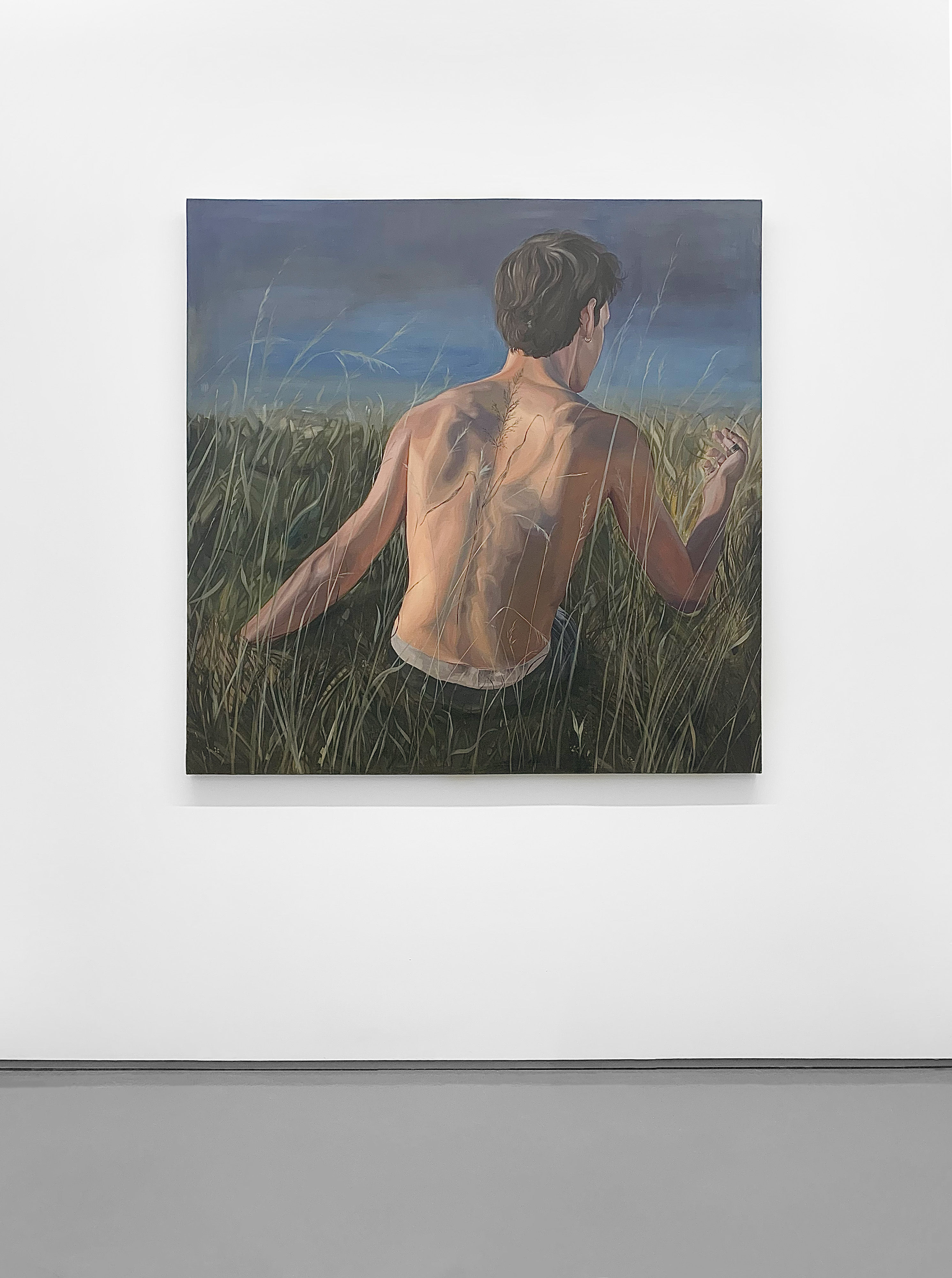 Image of painting of the back of a person with dark brown hair, sitting in a field of tall green grasses against a dark blue sky