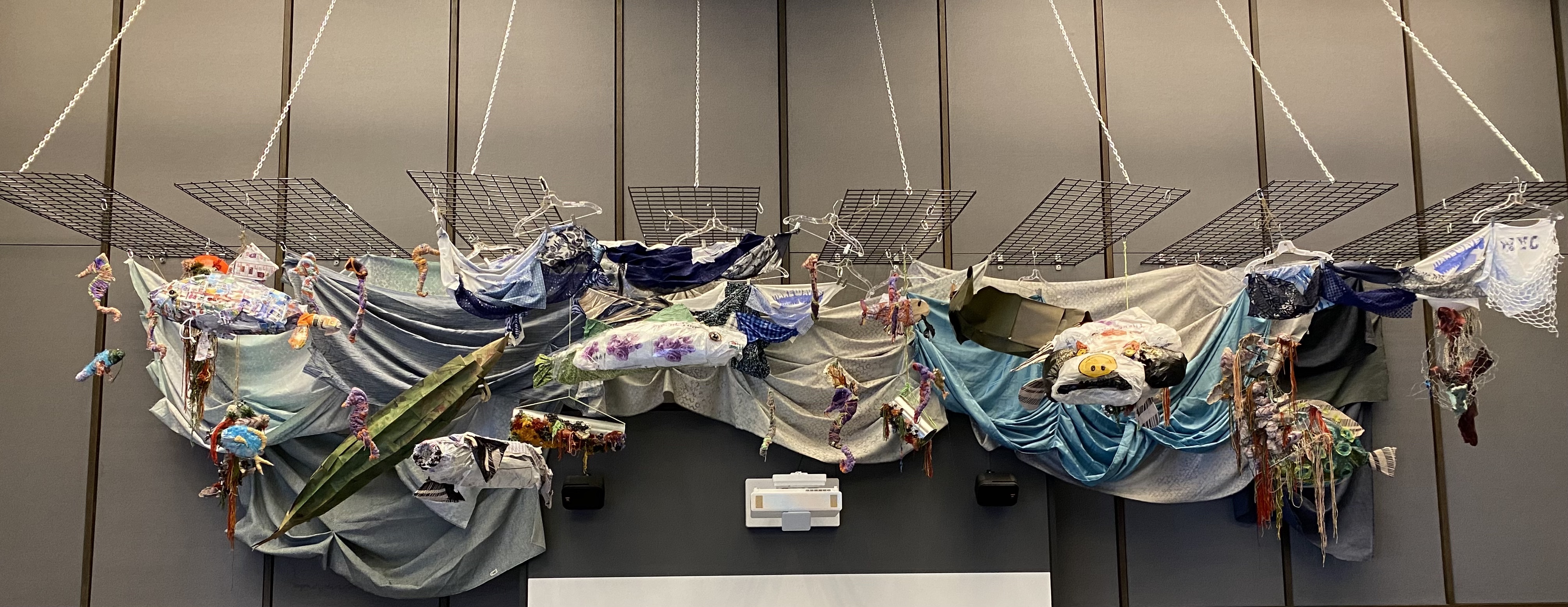 Hanging installation of multicolored sea creatures created out of found materials
