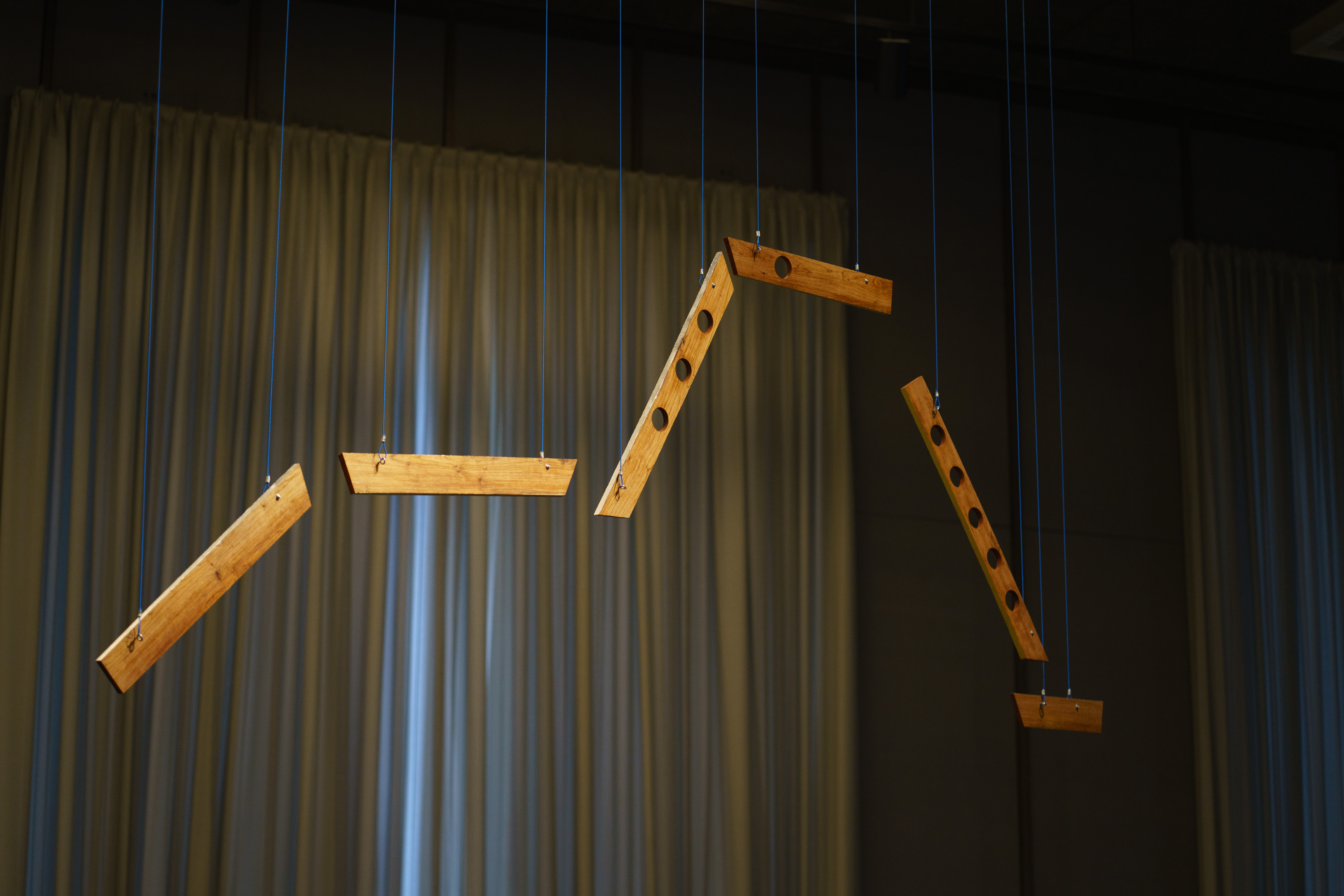 Detail image of pieces of wood suspended from the ceiling