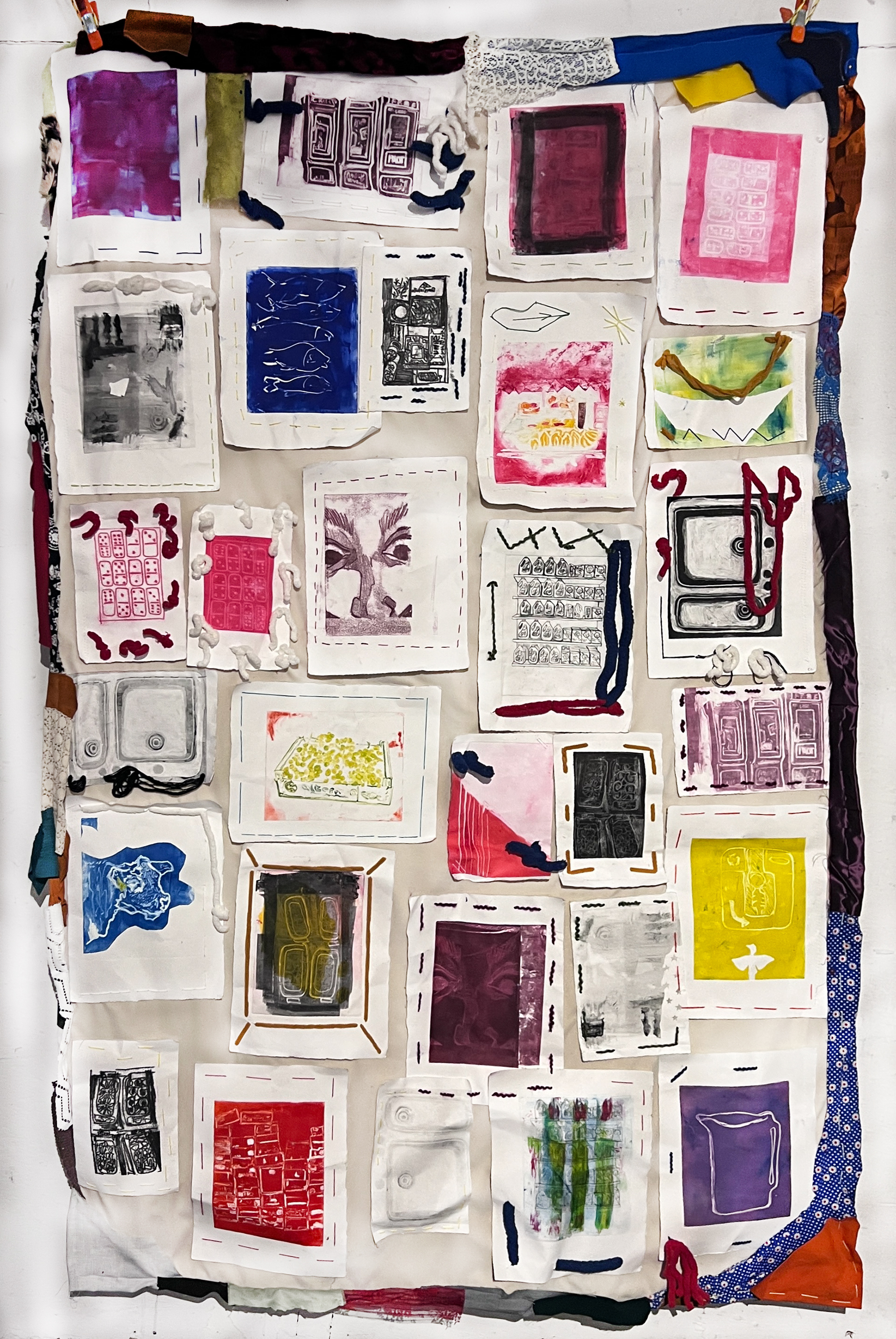 Image of rectangular quilt with smaller rectangles containing various etchings in white, red, black, yellow, purple, green, blue colors