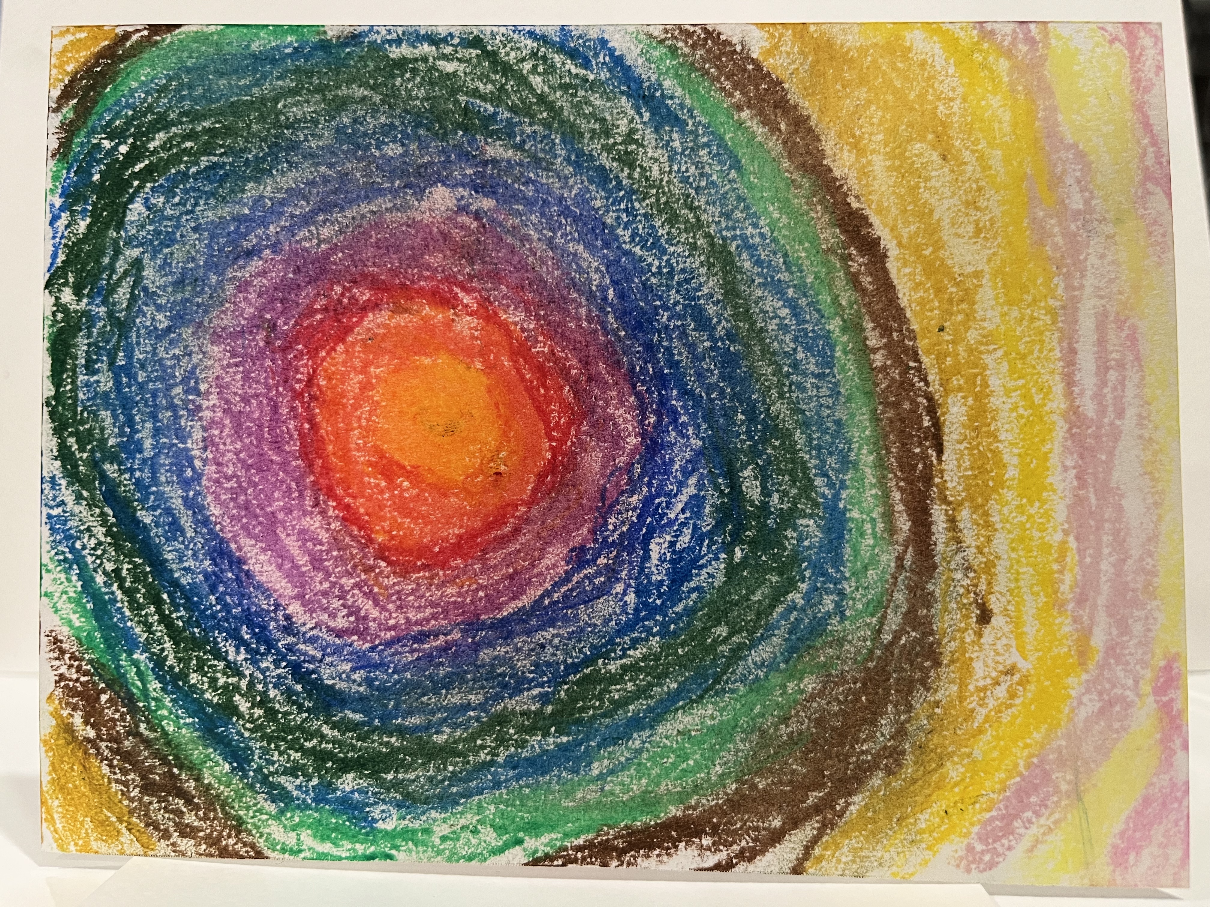 crayon print of a swirl of colors with an orange bullseye center