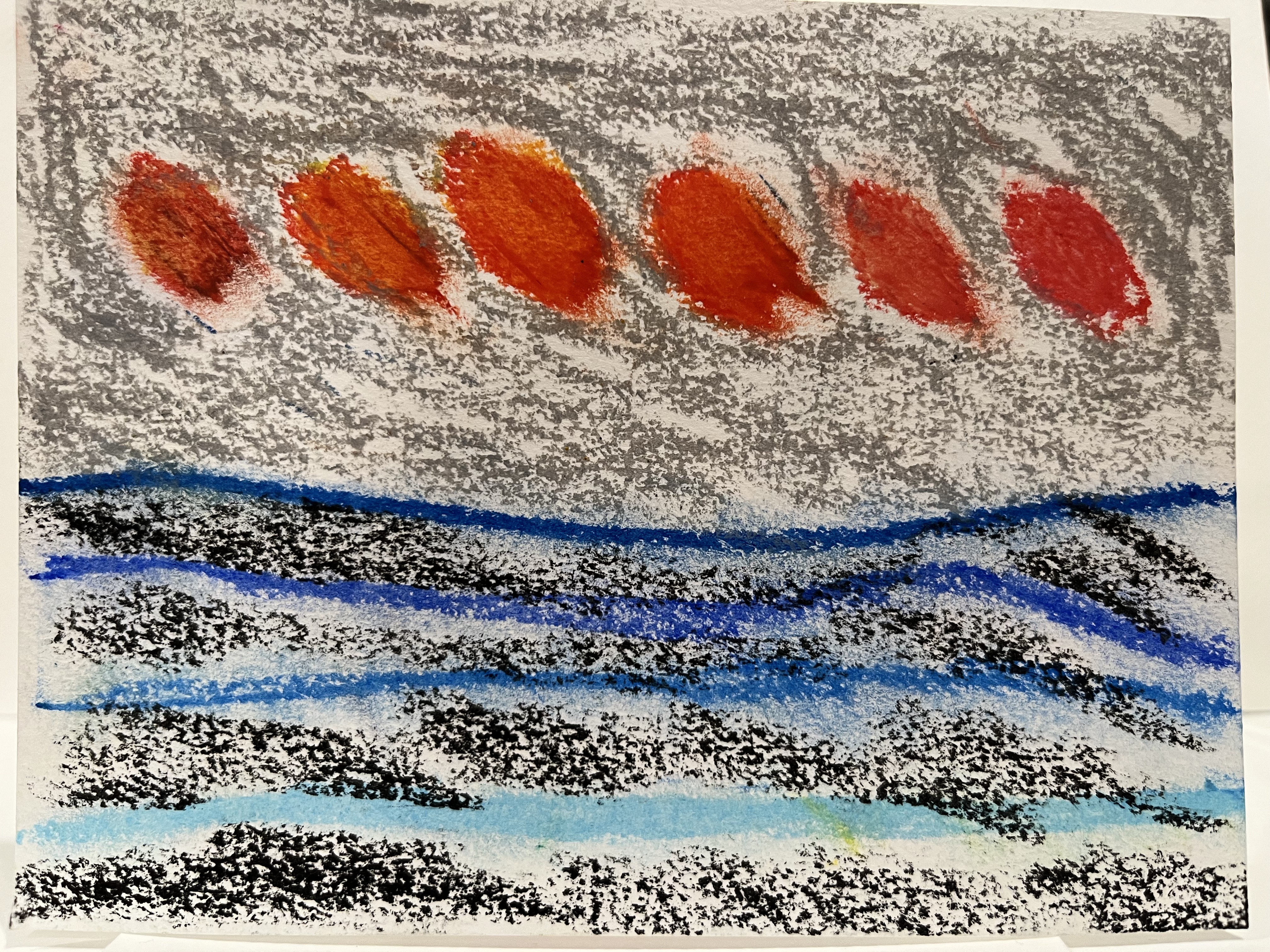 crayon print of six fiery dots against a grey sky above lined blue lines of ocean