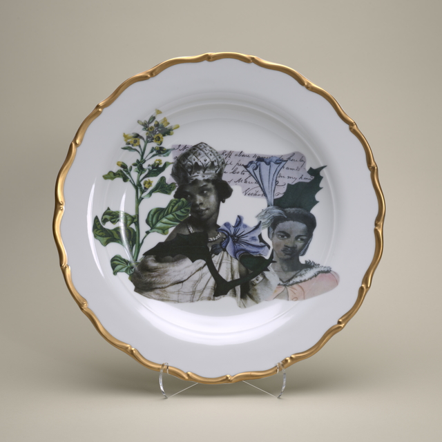 White porcelain plate with gold-rimmed edge and collage of two African women, a plant with green and yellow flowers, and a piece of paper with cursive handwriting